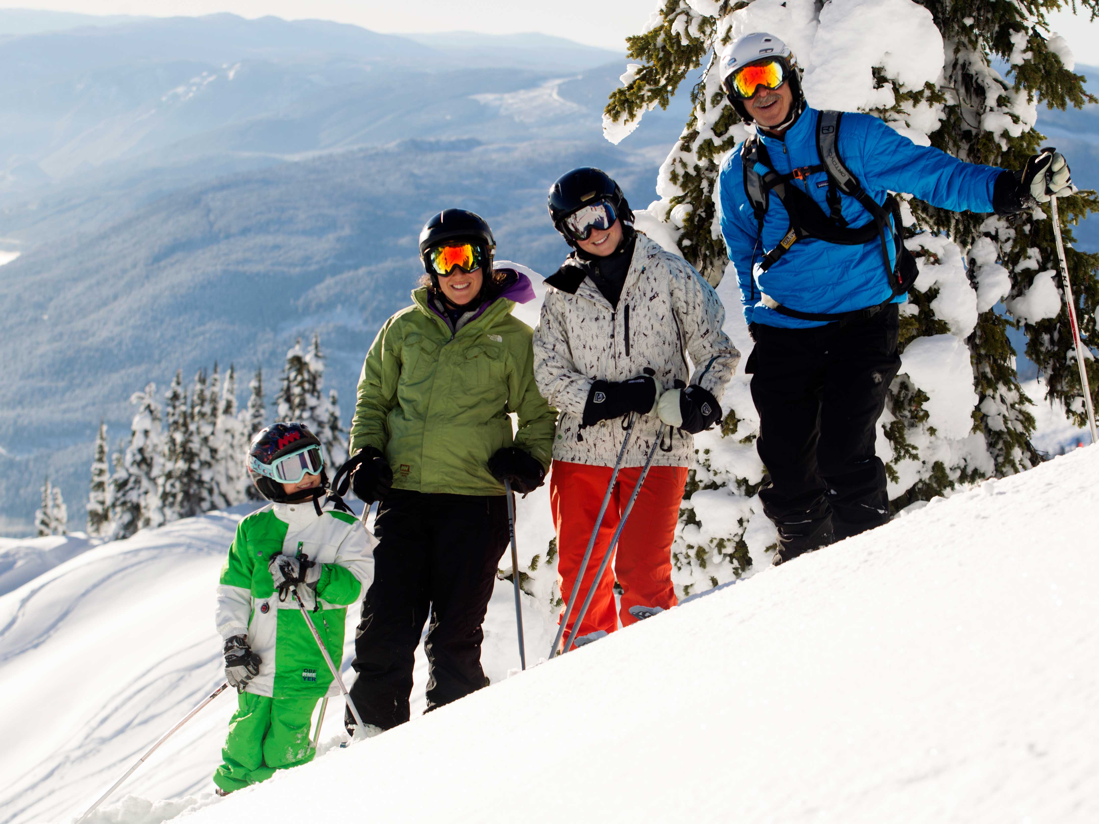 Family powder skiing and snowboarding at Mike Wiegele Heli-skiing in Blue River, BC, Canada.
