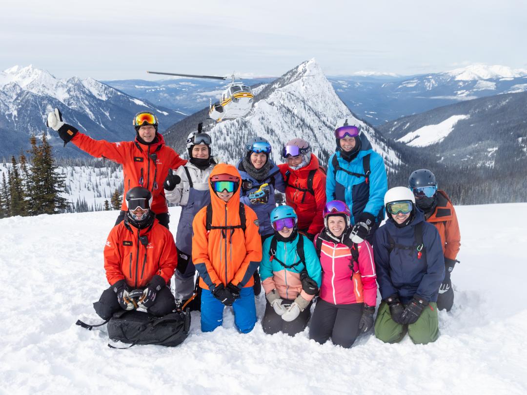 Heli-ski group with guides and helicopter