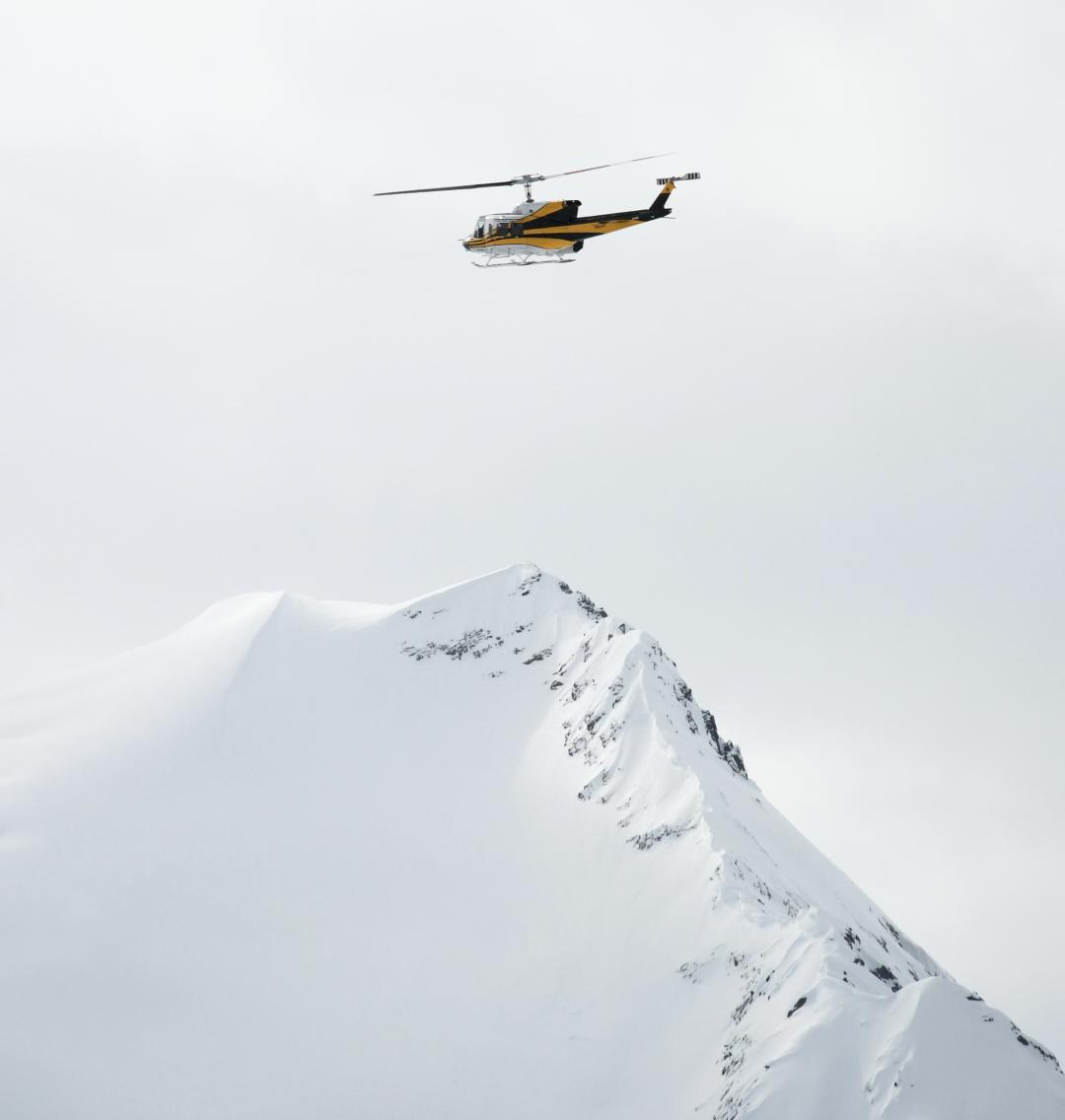 Heli flying above a peak